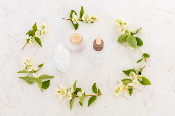 Body care products and branches of jasmine on the white background.