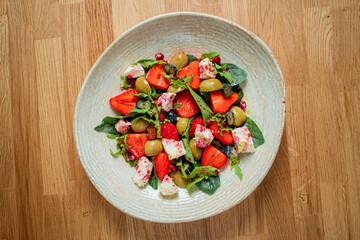 Vibrant salad with strawberries, olives, and feta cheese, beautifully arranged in a bowl
