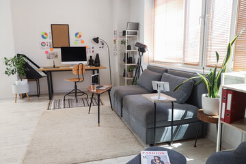 Stylish office with workplace, modern computer, sofa and photographer gadgets
