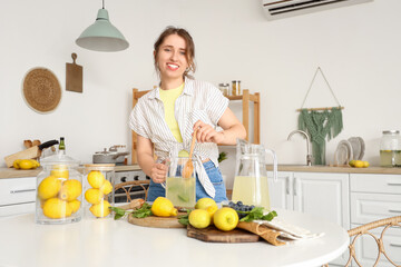 Young woman making lemonade in kitchen