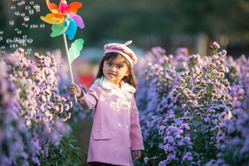 The children girl of vast flower field in full bloom stretches.