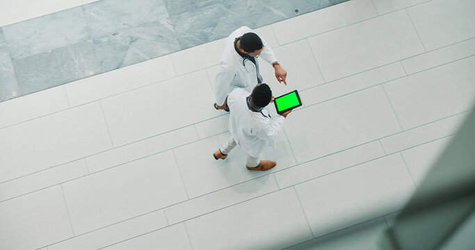 Men, doctor and medical team with tablet green screen at hospital for research, development or above. Top view, people or healthcare employees walking with technology display or mockup space for app