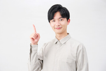 左側を指差す男性　20代　白背景