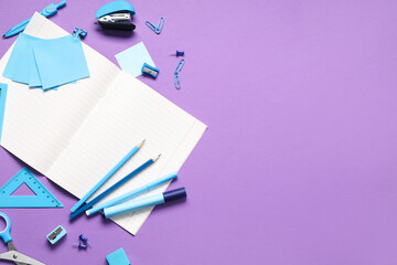 Blank notebook with different stationery supplies on purple background