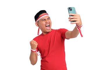 Excited young Asian men celebrate Indonesian independence day on 17 August while holding mobile phone isolated on transparent background