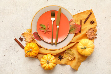 Beautiful table setting with fresh pumpkins, cinnamon, star anise and autumn leaves on white...