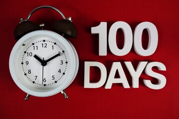 100 Days alphabet letters with alarm clock on red background