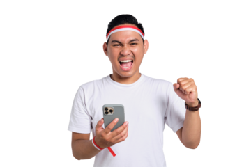 Excited young Asian man celebrate Indonesian independence day on 17 August while holding mobile phone isolated on transparent background