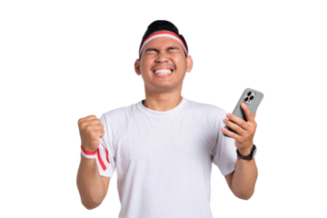 Excited young Asian man celebrate Indonesian independence day on 17 August while holding mobile phone isolated on transparent background