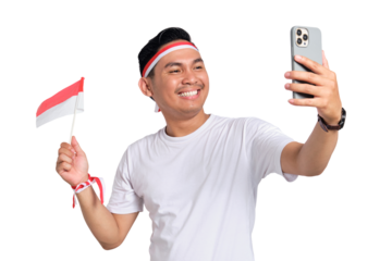 Excited young Asian men celebrate Indonesian independence day on 17 August while holding the Indonesian flag and mobile phone isolated on transparent background