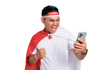 Excited young Asian man celebrate Indonesian independence day on 17 August while looking at cellphone screen with raised arms isolated on transparent background