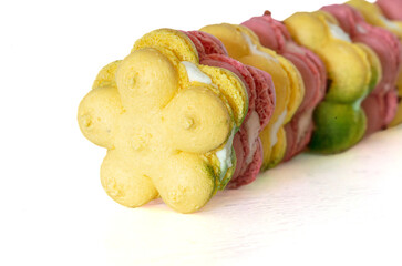 french macaron macaroon cookies in a curve row. bright strawberry pink and yellow green lemon, head on, close up, copy space