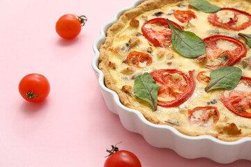 Delicious tomato tart with spinach leaves on pink background, closeup