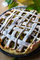 Pie with a lattice crust and powdered sugar on top. The crust is made of a pastry dough and the top...