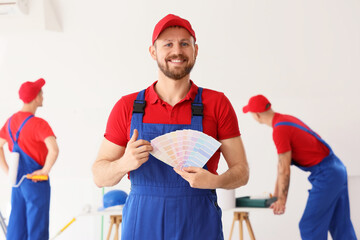 Male decorator with paint color palettes in room