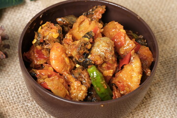 Sambal Goreng Hati Kentang or Hot Spicy Offal and Potatoes, Indonesian Traditional Cuisine, Typically Served During Eid Al-Fitr Celebration with Ketupat. Served on Brown Bowl, Wooden Background