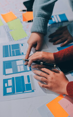 UX UI designer testing prototype on a phone, discussing and brainstorming on wireframes for a...