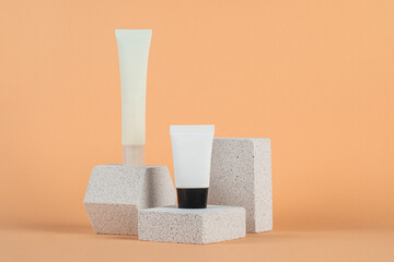Plastic white tube for cream or lotion. Skin care or sunscreen cosmetic with stylish props on cream...