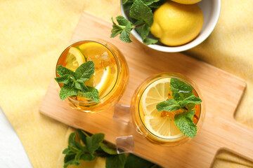 Glasses of lemon ice tea with mint on white background