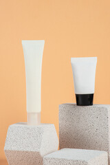 Plastic white tube for cream or lotion. Skin care or sunscreen cosmetic with stylish props on cream...