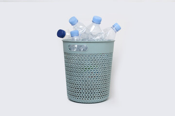 A light blue perforated basket, brimming with clear plastic water bottles, stands on a white...