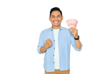 Excited young Asian man in casual clothes holding money and clenching fist, celebrating financial success isolated on transparent background. Profit and wealth concept