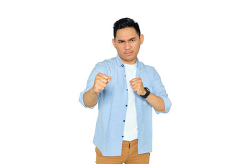 Angry young Asian man in casual clothes ready to fight with fist defense gesture isolated on...