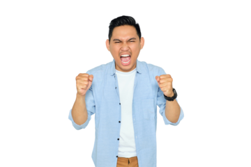 Excited young handsome Asian man in casual clothes making winner gesture with raising fist, celebrating success isolated on transparent background. Goal achievement concept