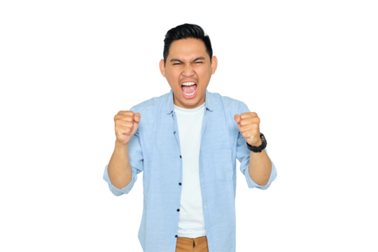 Excited young handsome Asian man in casual clothes making winner gesture with raising fist, celebrating success isolated on transparent background. Goal achievement concept