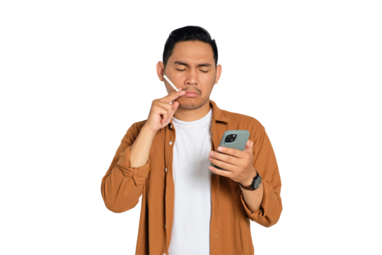 Portrait of young Asian man in casual shirt reading news on smartphone while smoking cigarette isolated on transparent background