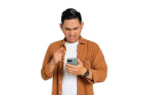 Angry young Asian man in casual shirt pointing with finger at his smartphone isolated on transparent background - Powered by Adobe