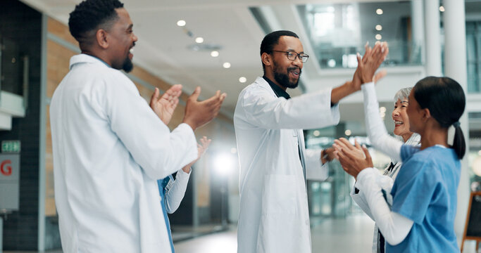 Healthcare, doctor and group with smile, high five or clapping for success, celebration or hospital. Happy, medical professional and applause for achievement in clinic, support and gesture for win