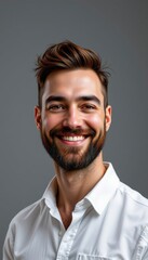 Obraz premium Cheerful young man with stylish haircut and beard smiling warmly against neutral background in professional portrait setting