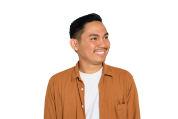 Smiling young Asian man in casual shirt looking aside at copy space isolated on transparent background
