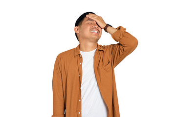 Forgetful young Asian man in casual shirt slapping hand on head having duh moment isolated on...