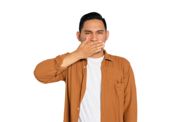 Handsome young Asian man in casual shirt covering mouth with hand palm, looking at camera isolated on transparent background