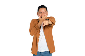 Happy young Asian man in casual shirt pointing with finger at someone and laughing isolated on...