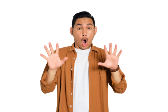 Portrait of scared young Asian man in casual shirt keeping hands raised to defend himself isolated on transparent background