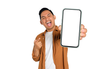 Excited young Asian man in casual shirt holding smartphone with blank screen, pointing at device...