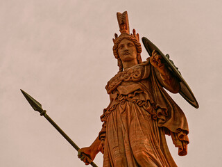 Statue of Athena, the Greek goddess of wisdom and knowledge, with helmet, spear and large shield....