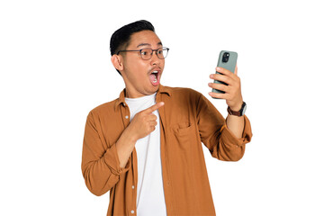 Surprised young Asian man in casual shirt using mobile phone with open mouth, reading great news message isolated on transparent background
