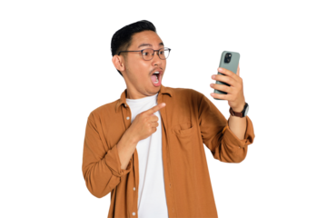 Surprised young Asian man in casual shirt using mobile phone with open mouth, reading great news message isolated on transparent background