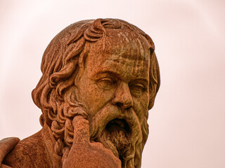 Stone sculpture of Socrates, the ancient Greek philosopher, portraying deep contemplation against a timeless backdrop. Classical representation of wisdom and intellectual legacy.