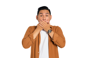 Surprised young Asian man in casual shirt covering mouth with hand, looking at camera with amazed facial expression isolated on transparent background