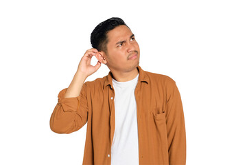 Doubtful young Asian man in casual shirt scratching head, thinking, trying to find solution...