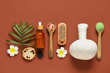 Composition with bath supplies, bottle of cosmetic product and spoons with sea salt on brown background