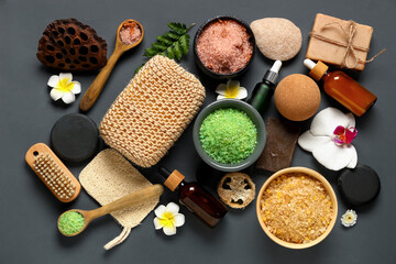 Composition with bath supplies, flowers and bowls of sea salt on grey background