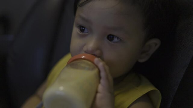 Toddler Is Drinking Milk From A Bottle, Video footage for documentary and cinematic in dink milk scene.