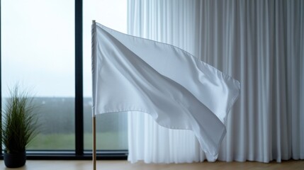 A white flag stands tall in a sleek indoor setting with large windows showcasing a grey, overcast sky. The environment feels calm, enhancing the flag's significance.