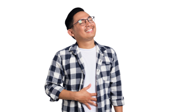 Happy young Asian man in casual shirt feeling happy after eating delicious food, rubbing belly and smiling isolated on transparent background